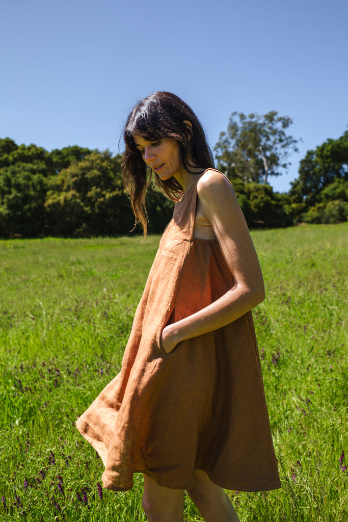 This noon dress is made in collaboration between Erica Kim and World of Crow, it has linen fabric, Brown rustic color, sleeveless, above knee-length dress, it is sustainably made and true to size