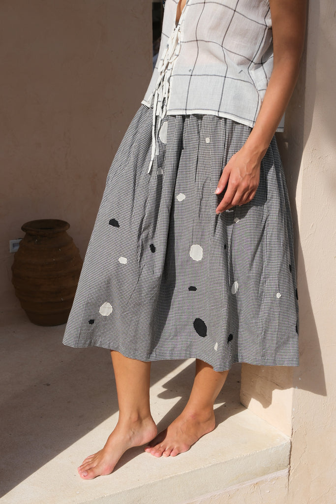 Introducing our All Dots Are Not Black Skirt, a collaboration between Audrey E Leary and World of Crow. This grey midi skirt showcases distinctive black and white polka dots on handwoven cotton, offering both comfort and style. Sustainably made, it's perfect for everyday wear.