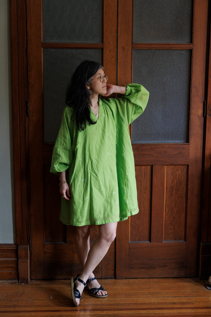 This Pride of Crow mini dress is made in collaboration between Erica Kim and World of Crow, it has a frilled round V-neckline, Sorbet green colour, A-line flare, Drop shoulders, Long gathered cuff sleeves, side pockets, Oversized fit in Jamdani fabric