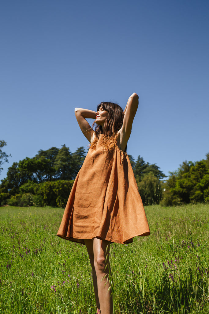 This noon dress is made in collaboration between Erica Kim and World of Crow, it has linen fabric, Brown rustic color, sleeveless, above knee-length dress, it is sustainably made and true to size