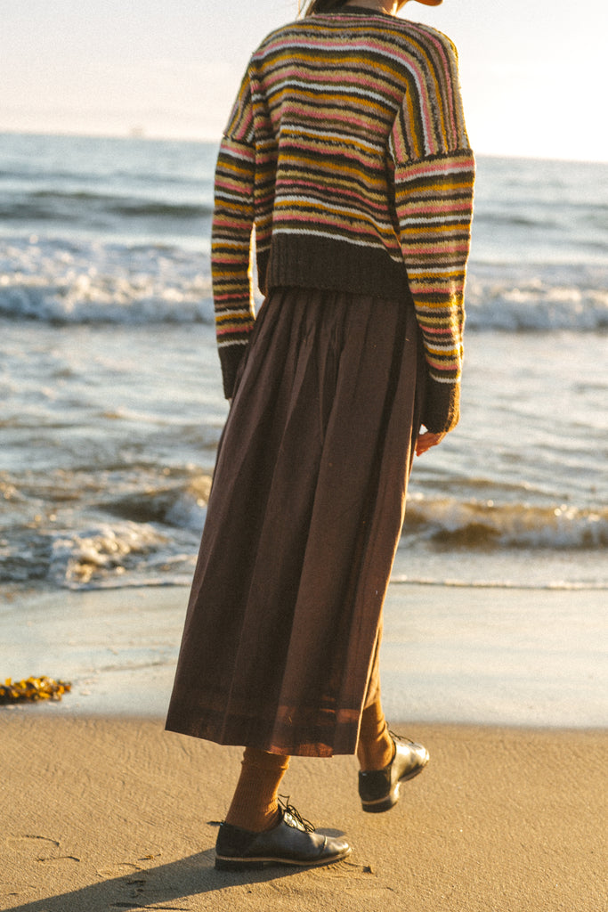 The Chocolate Brown Pull-On Skirt blends comfort and elegance. Made from handwoven cotton, it features a mid-rise elasticated waistband and a mid-calf length for a relaxed yet polished look