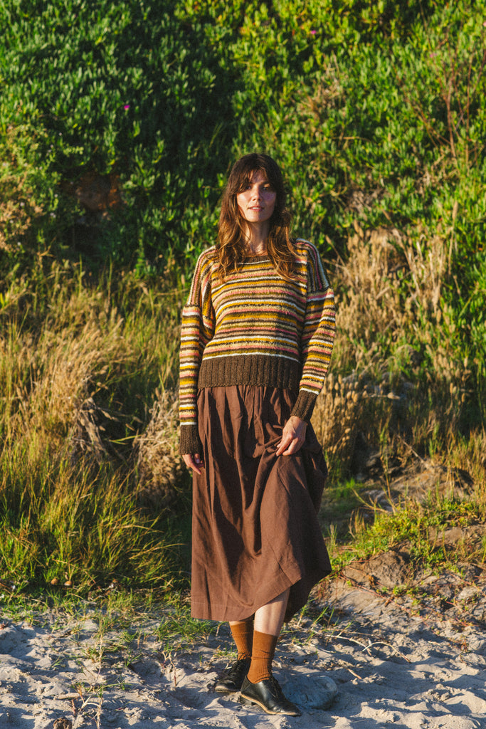 The Chocolate Brown Pull-On Skirt blends comfort and elegance. Made from handwoven cotton, it features a mid-rise elasticated waistband and a mid-calf length for a relaxed yet polished look