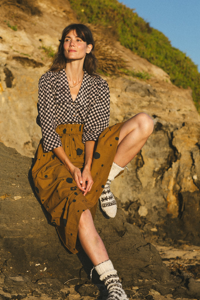 The Circles All Over Skirt features a striking brown and navy block print with circular patterns. Made from 100% handwoven cotton, it offers a comfortable mid-rise elasticated waistband and a chic mid-calf length, perfect for a polished yet relaxed style.