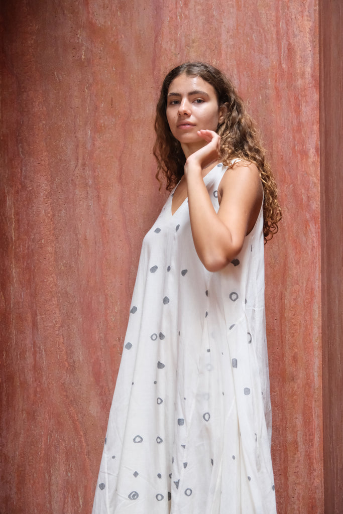 Introducing the Holiday Slip Dress, a collaboration between Audrey E Leary and World of Crow. This off-white, midi-length dress features playful polka dots and is made from soft, handwoven Jamdani cotton. Its sleeveless, lightweight design is perfect for layering and versatile styling, offering both elegance and practicality.