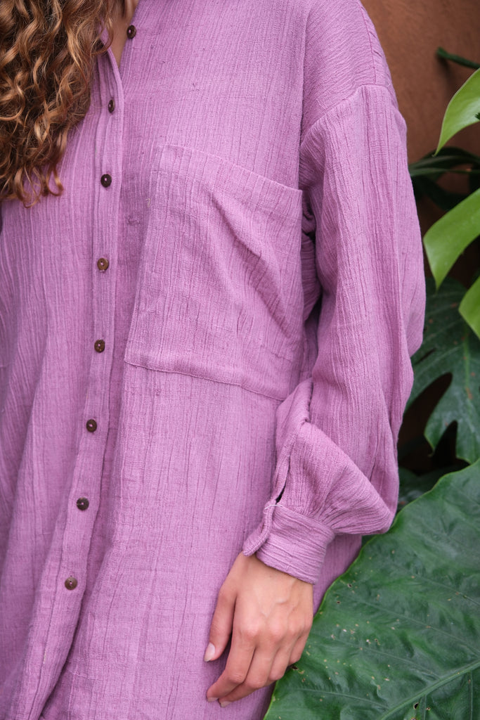 Introducing the Artist Smock, a collaboration between Audrey E Leary and World of Crow. This pink dual-tone smock is crafted from thick, handwoven organic cotton and features a straight collar, puff full sleeves, and spacious pockets. With a short length and gathered cuffs, it offers a comfortable fit and is perfect for painting, crafting, and staying cozy during travel.