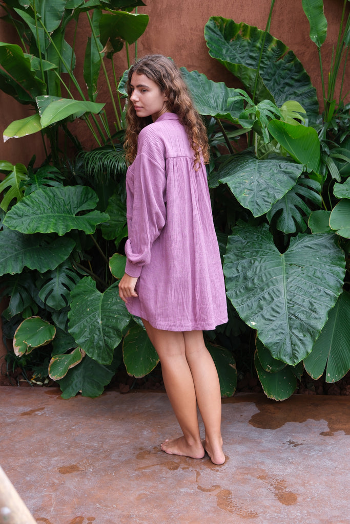 Introducing the Artist Smock, a collaboration between Audrey E Leary and World of Crow. This pink dual-tone smock is crafted from thick, handwoven organic cotton and features a straight collar, puff full sleeves, and spacious pockets. With a short length and gathered cuffs, it offers a comfortable fit and is perfect for painting, crafting, and staying cozy during travel.