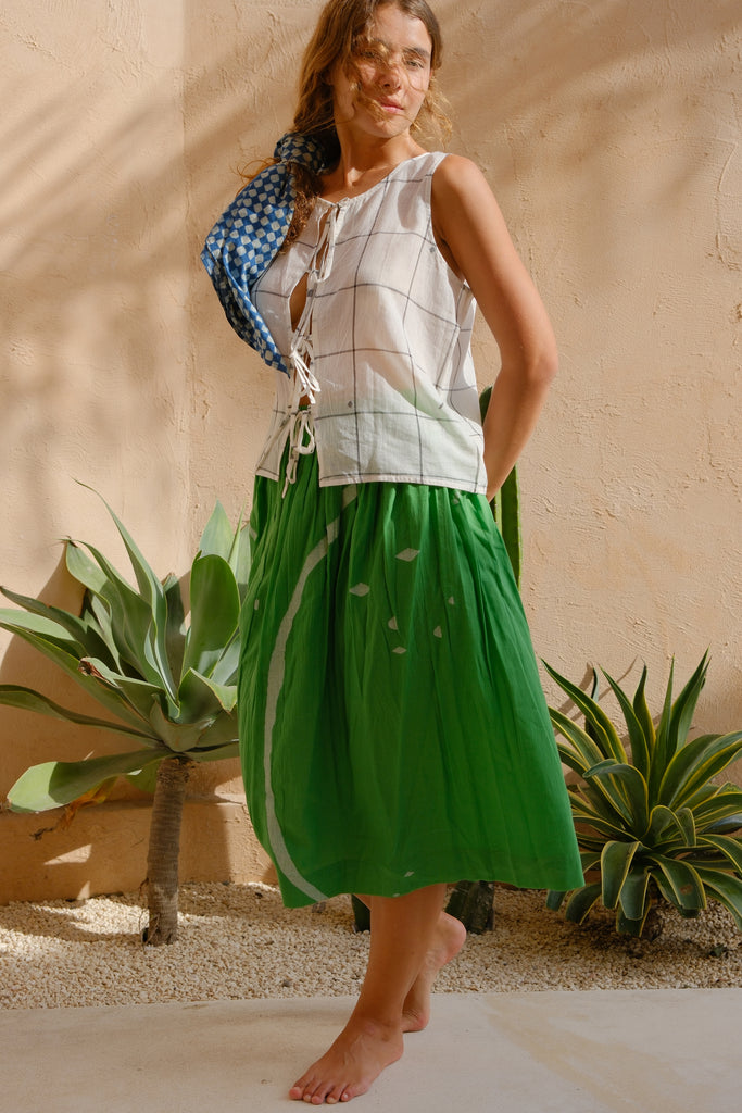 Introducing the Mega-Mega Skirt, a collaboration between Audrey E Leary and World of Crow. This green midi-length skirt features a jamdani pattern and is made from soft, handwoven cotton. Sustainably crafted, it offers a comfortable fit ideal for everyday wear.